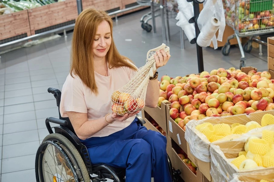 Disabled woman in wheelchair grocery shopping