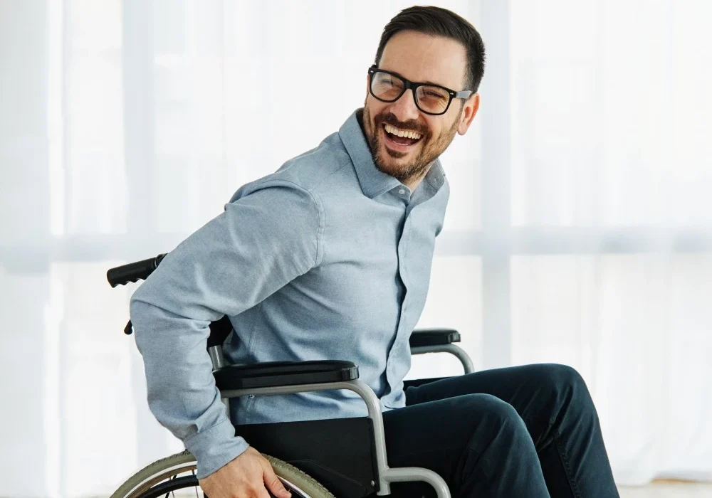Happy man in wheelchair smiling and looking past camera